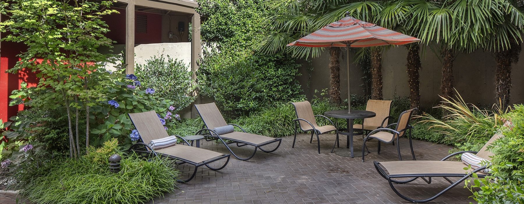 a patio with chairs and umbrella