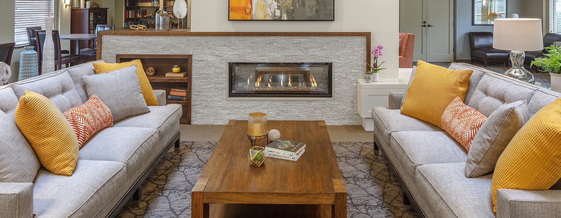 a clubroom with a coffee table, fireplace and couches