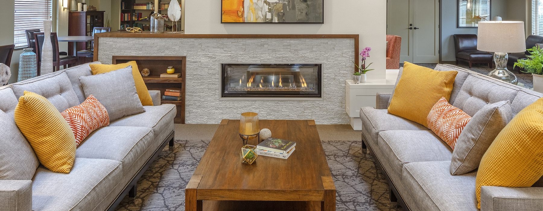 a clubroom with a coffee table, fireplace and couches