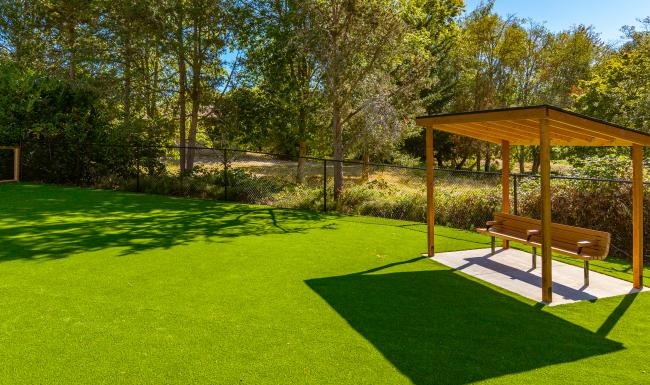 a dog park with a covered seating area